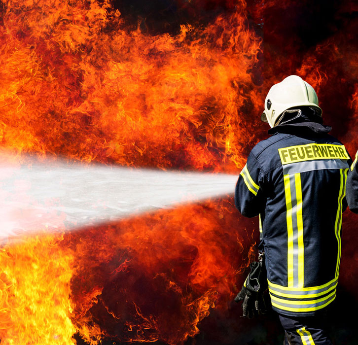 Feuerwehreinsatz mit Löschschlauch im Sprüheinsatz